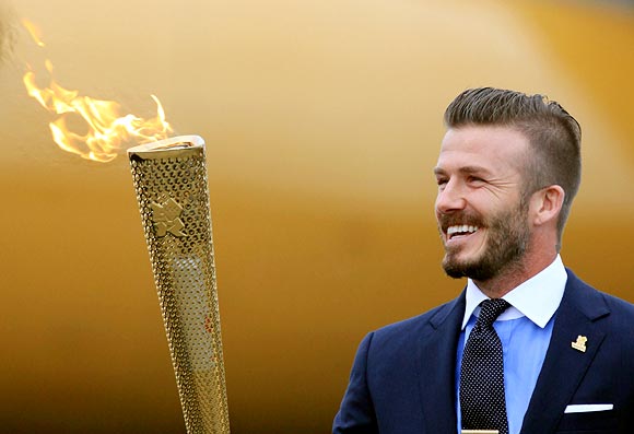 David Beckham holds the Olympic Flame as it arrives at RNAS Culdrose near Helston