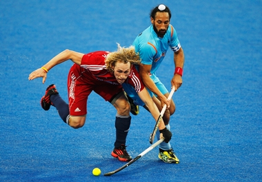 Sardar Singh tackles Richard Alexander of Great Britain on the blue turf during the Olympics test event in London