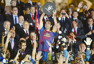 Barcelona's Xavi Hernandez lifts up the Spanish King's Cup trophy after winning their final against Athletic Bilbao