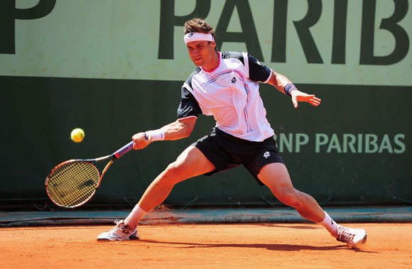 David Ferrer of Spain slides to play a forehand in the men's singles first round match against Lukas Lacko of Slovakia