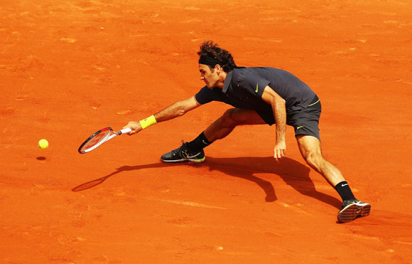 Roger Federer of Switzerland reaches for a forehand during his men's singles second round match against Adrian Ungur of Romania during day four of the French Open at Roland Garros in Paris