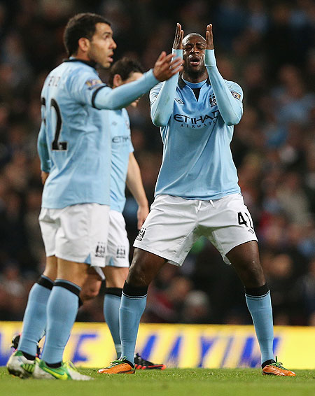 aya Toure of Manchester City shows his frustration as Carlos Tevez watches