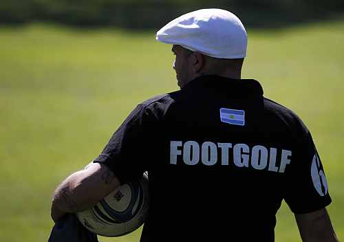 A man carries his soccer ball as he waits for his turn to compete in a FootGolf tournament