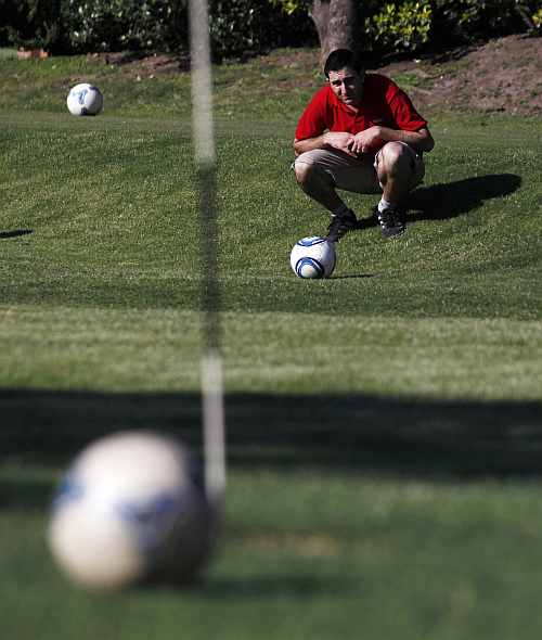 A player lines up a putt as he competes in a FootGolf tournament