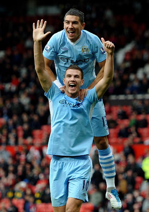 Edin Dzeko of Manchester City celebrates scoring his team's sixth goal with team mate Aleksandar Kolarov during the Barclays Premier League match between Manchester United