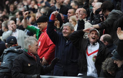 Manchester United fans celebrate hearing news of a goal by QPR at Manchester City during the Barclays Premier League match between Sunderland and Manchester United