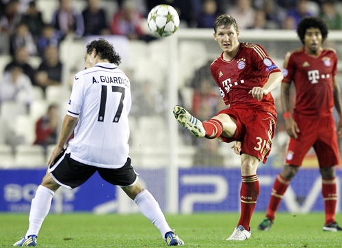 Bayern Munich's Bastian Schweinsteiger (right) kicks the ball past Valencia's Andres Guardado