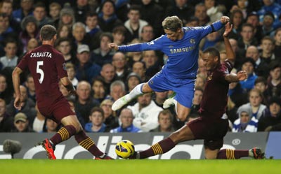 Chelsea's Fernando Torres (C) is tackled by Manchester City's Pablo Zabaleta (L) and Vincent Kompany during their English Premier League soccer match
