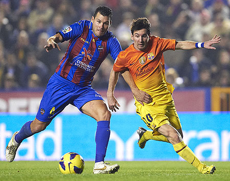 David Navarro (left) of Levante and Lionel Messi of Barcelona vie for possession during their la Liga match on Sunday