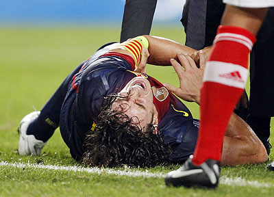 Barcelona's Carles Puyol grimaces after falling and sustaining an injury during their Champions League match against Benfica on Tuesday