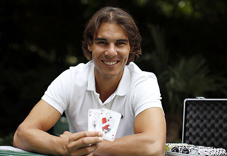 Rafael Nadal hols up playing cards depicting some of his 11 Grand Slam victories