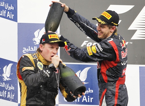 Sebastian Vettel pours champagne on second placed Lotus F1 Formula One driver Kimi Raikkonen