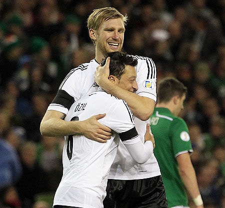 Germany's Per Mertesacker congratulates Mesut Ozil (front) after he scored against Ireland
