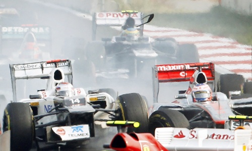 Sauber Formula One driver Kamui Kobayashi (left) of Japan collides with McLaren driver Jenson Button
