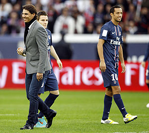 Rafael Nadal (left) walks past Paris St Germain's Nene (right) and Kevin Gameiro (centre) before the French Ligue 1 soccer match between Paris Saint Germain and Reims at the Parc des Princes stadium in Paris on Saturday