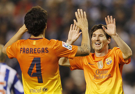 Barcelona's Lionel Messi (right) celebrates with teammate Cesc Fabregas aftr scoring against Deportivo Coruna