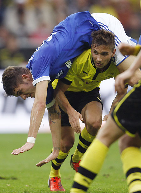 Schalke 04's Roman Neustaedter falls onto Borussia Dortmund's Moritz Leitner (right) during their Bundesliga match on Saturday