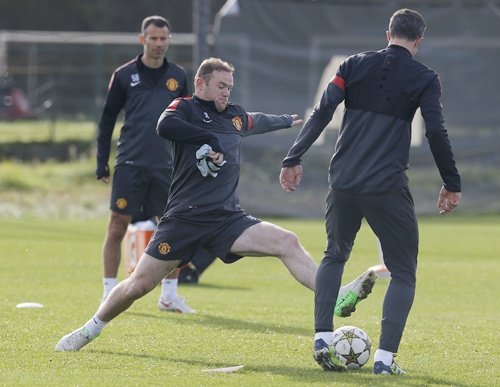 Manchester United's Wayne Rooney (centre) challenges for the ball during a   training session