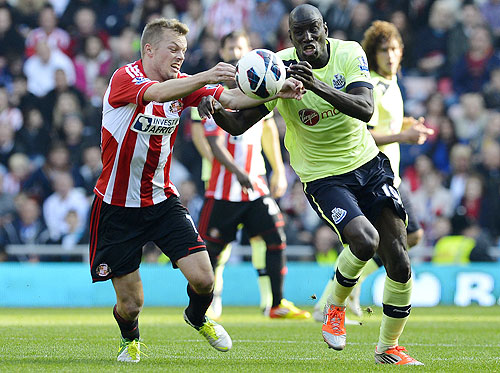 Sunderland's Sebastian Larsson (left) challenges Newcastle United's Demba Ba