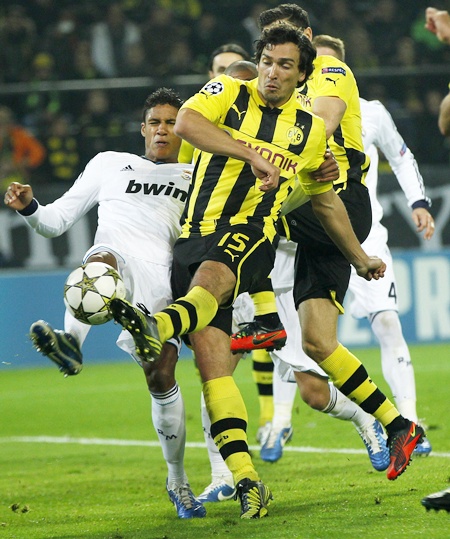 Real Madrid's Raphael Varane (left) fights for the ball with Borussia   Dortmund's Mats Hummels