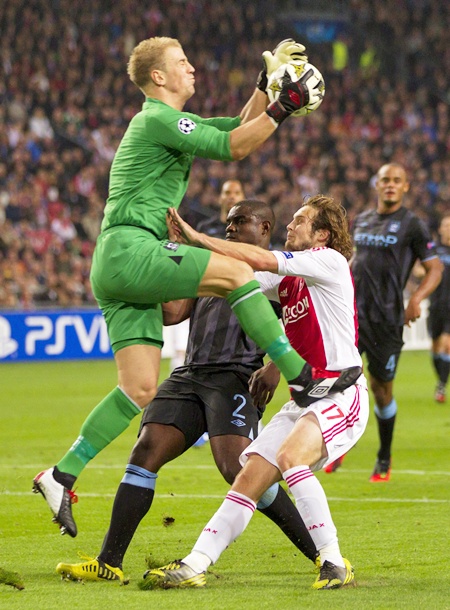 Daley Blind of Ajax Amsterdam (right) fights for the ball with Manchester City's goalkeeper Joe Hart