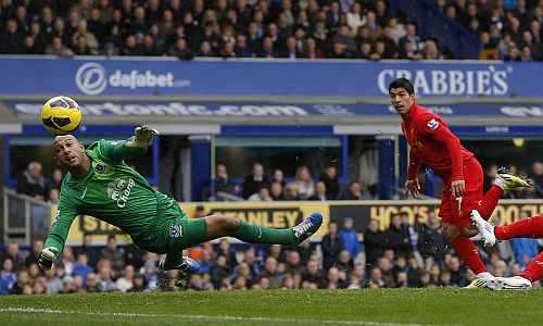 Everton's Tim Howard fails to keep out a header by Liverpool's Luis Suarez during their English Premier League soccer match at Goodison Park