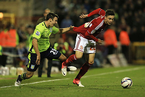 Miles Storey of Swindon Town is challenged by Enda Stevens of Aston Villa during their match on Tuesday