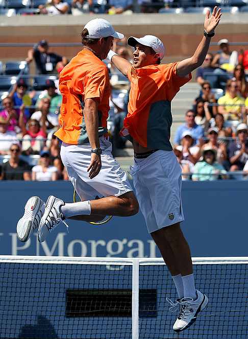 Bob Bryan (L) and Mike Bryan (R) celebrate match point with a chest bump against Leander Paes and Radek Stepanek