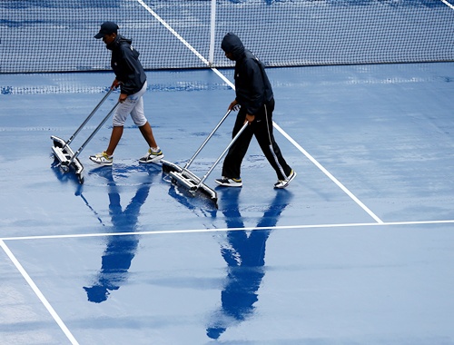 Grounds crew dry the court after rain suspened action