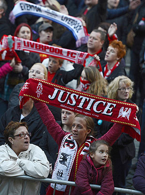 Members of the crowd react during a vigil at St George's Hall in Liverpool