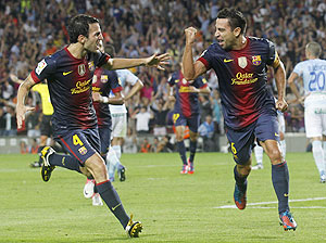 Barcelona's Xavi Hernandez (right) celebrates with teammate Cesc Fabregas after scoring against Granada during their La Liga match at Camp Nou on Saturday