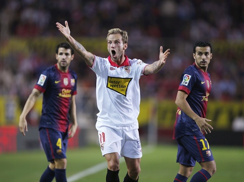 Sevilla's Ivan Rakitic (centre) reacts next to Barcelona's Cesc Fabregas (left) and Pedro Rodriguez