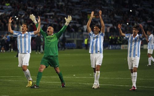 Malaga's players celebrate their victory over Porto