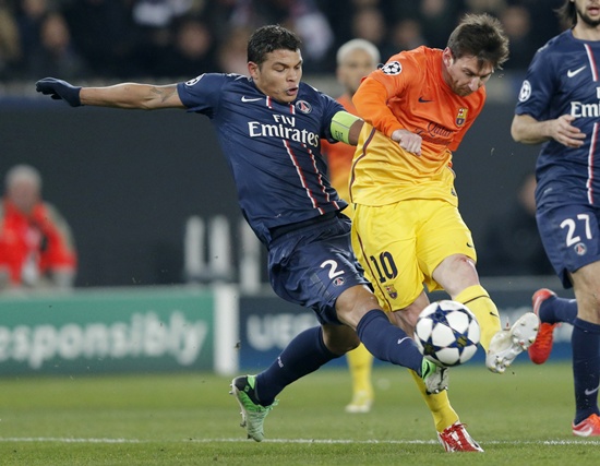 Paris St Germain's Thiago Silva (left) challenges Barcelona's Lionnel Messi