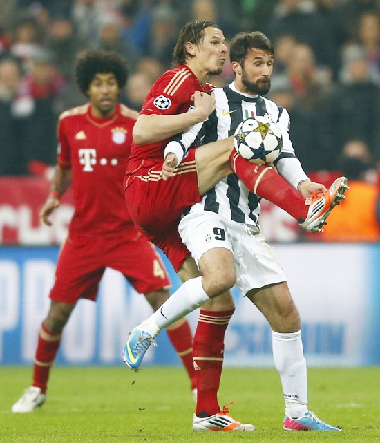 Daniel van Buyten (left) of Bayern Munich challenges Mirko Vucinic of Juventus