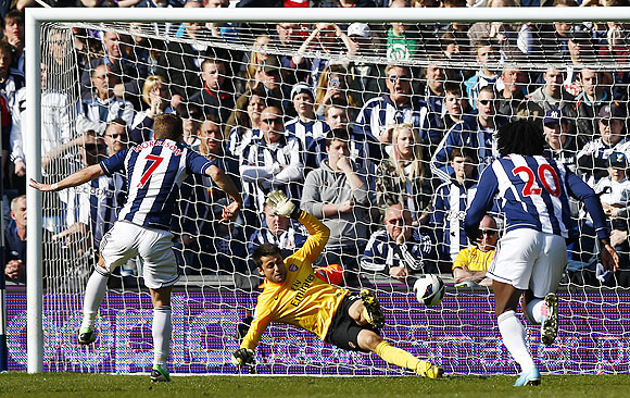 West Bromwich Albion's James Morrison (left) scores a penalty past Arsenal's Lukasz Fabianski during their English Premier League match at the Hawthorns in West Bromwich, on Saturday