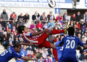 Atletico Madrid's Radamel Falcao (centre) tries to kick the ball between Getafe's Albert Lopo (left) and Juan Valera