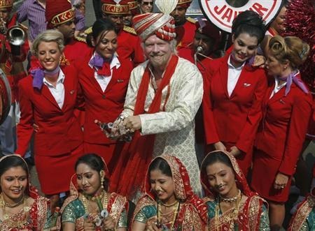 Virgin Group founder Richard Branson poses with his crew members and a group of Indian folk artists (bottom) during a promotional event in Mumbai October 26, 2012