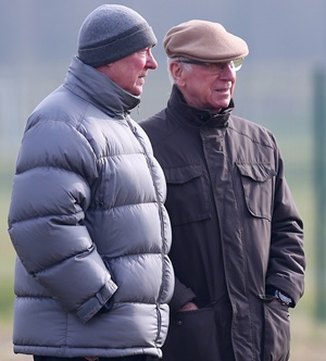 Sir Alex Ferguson the manager of Manchester United talks with Sir Bobby Charlton