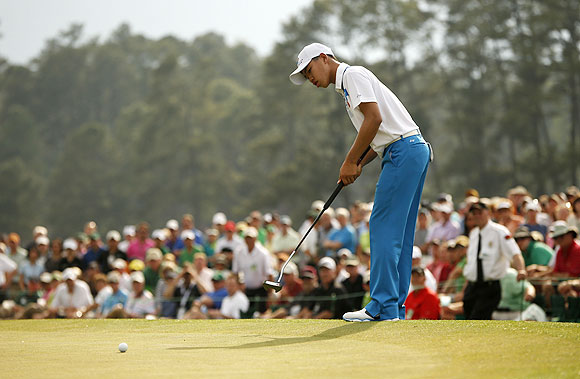 Fourteen-year-old amateur Guan Tianlang of China sinks a birdie putt on the 18th green during first round play in the 2013 Masters golf tournament at the Augusta National Golf Club in Augusta, Georgia, on Thursday