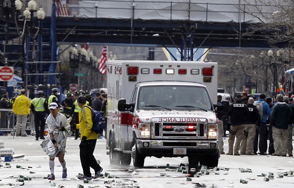 A runner is escorted from the scene after explosions went off at   the 117th Boston Marathon in Boston