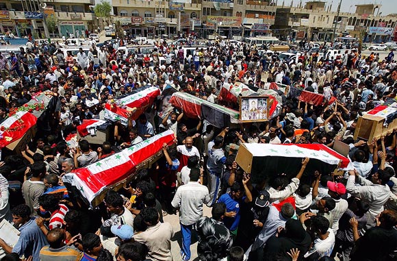 Iraqis carry coffins containing the remains of members of the Iraqi taekwondo national team in Baghdad, on June 16, 2007.