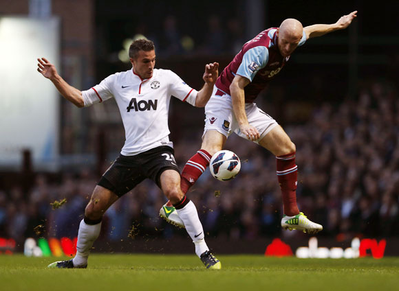 West Ham United's James Collins (right) challenges Manchester United's Robin van Persie during their English Premier League match at The Boleyn Ground on Wednesday