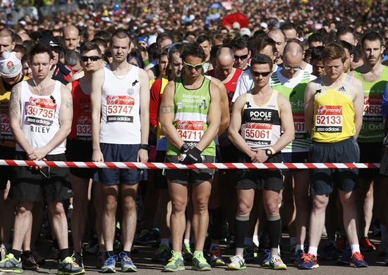 Runners observe a moment of silence before the start of the London Marathon