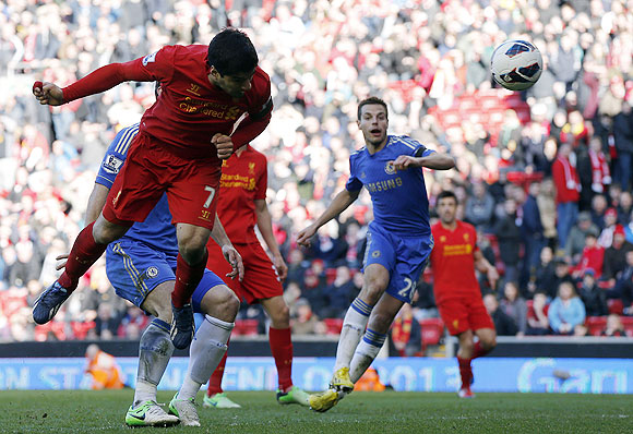 Liverpool's Luis Suarez (left) scores against Chelsea during their English Premier League match at Anfield on Sunday