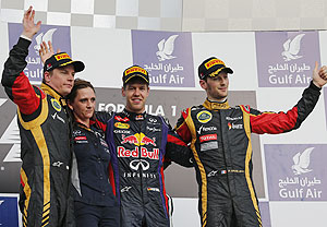 Red Bull's Sebastian Vettel (2nd from right), Lotus' Kimi Raikkonen (left) and Romain Grosjean (right) celebrate with Red Bull Formula One's Head of Trackside Electronics Gill Jones during the victory ceremony at the Sakhir circuit during the Bahrain GP on Sunday