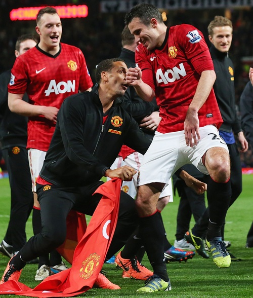 Rio Ferdinand of Manchester United tries to pull Robin van   Persie's shorts as they celebrate