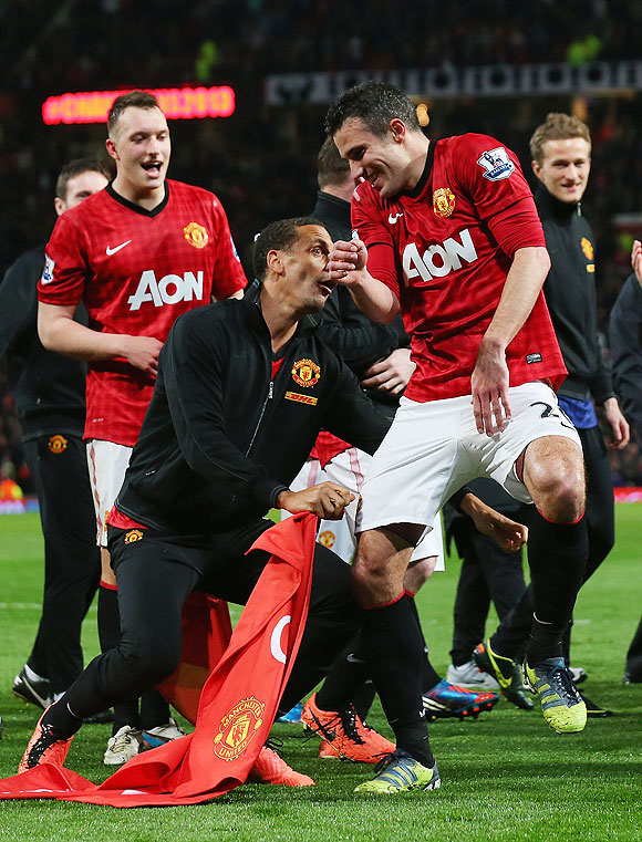 Manchester United's Rio Ferdinand jokes with teammate Robin van Persie on Monday