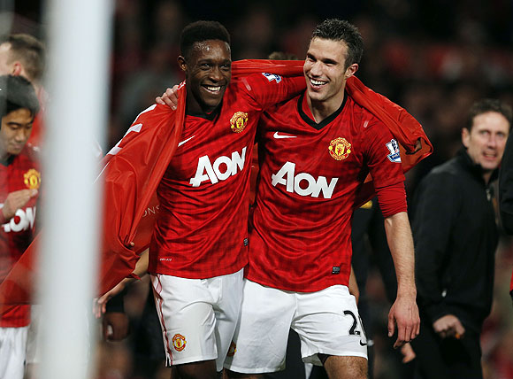 Manchester United's Robin Van Persie (right) celebrates with teammate Danny Welbeck after clinching the English Premier League title on Monday