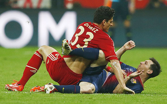 Bayern Munich's Mario Gomez (left) falls on top of Barcelona's Lionel Messi during their Champions League semi-final first leg match in Munich, on Tuesday